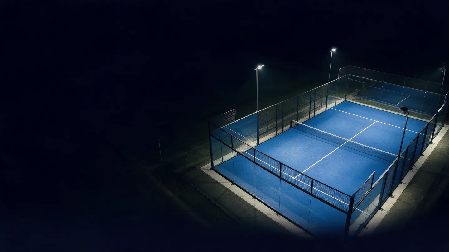 Visualisation nocturne d’une piste de padel éclairée et entourée de parois vitrées.